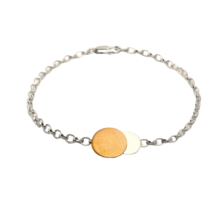 Discover the Gallardo & Blaine Designs Archeol Bracelet in Sterling Silver & Gold Vermeil with a delicate silver bracelet featuring two overlapping circular disks at its center, one in gold vermeil and the other in silver. The chain has small, uniform links and a clasp closure. The design is minimalist and elegant.