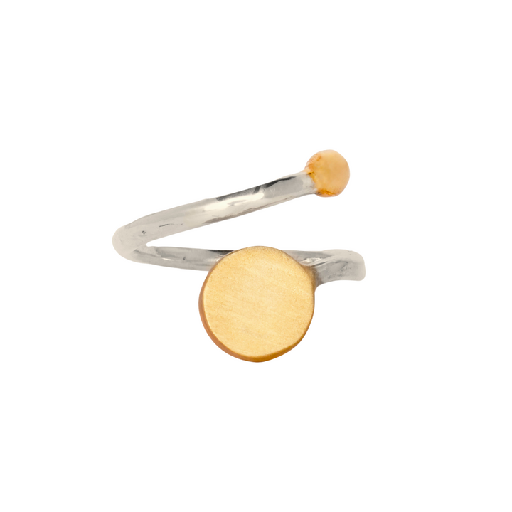 The Archeol Ring in Sterling Silver & Gold Vermeil by Gallardo & Blaine Designs features a minimalist design with a small round amber stone on one end and a larger flat circular gold vermeil disk on the other. The band is slightly twisted for a modern, sophisticated look.