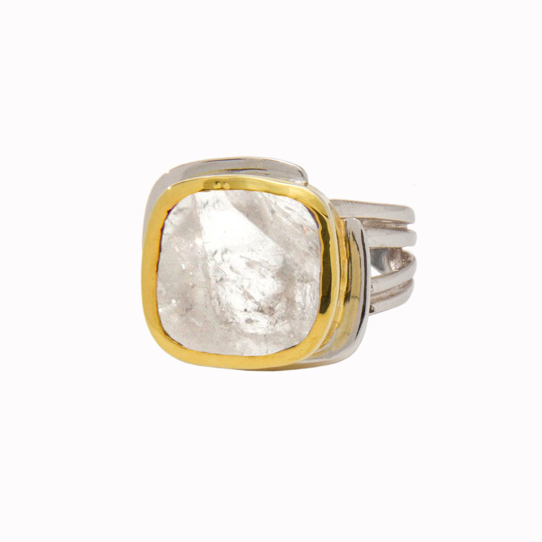 The Adjustable Art Deco Ring by Gallardo & Blaine Designs features a sterling silver band with a modern, layered look and a large translucent gemstone with an irregular appearance set in a gold bezel.