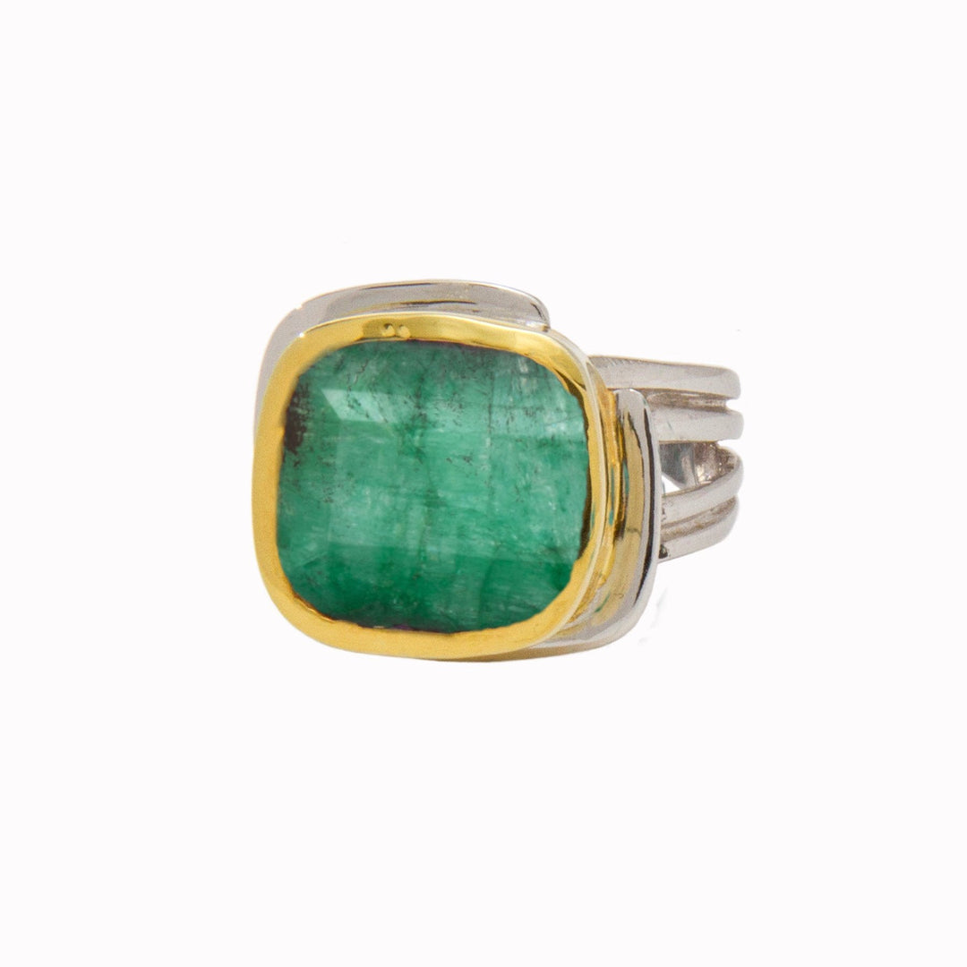 A square-cut green gemstone, possibly an emerald, is set in a sterling silver band ring with a gold vermeil bezel. The Art Deco Ring in Silver Gold & various gemstones by Gallardo & Blaine Designs features a broad, slightly curved design with multiple bands merging into a single shank. The gemstone has a translucent, rich green color.