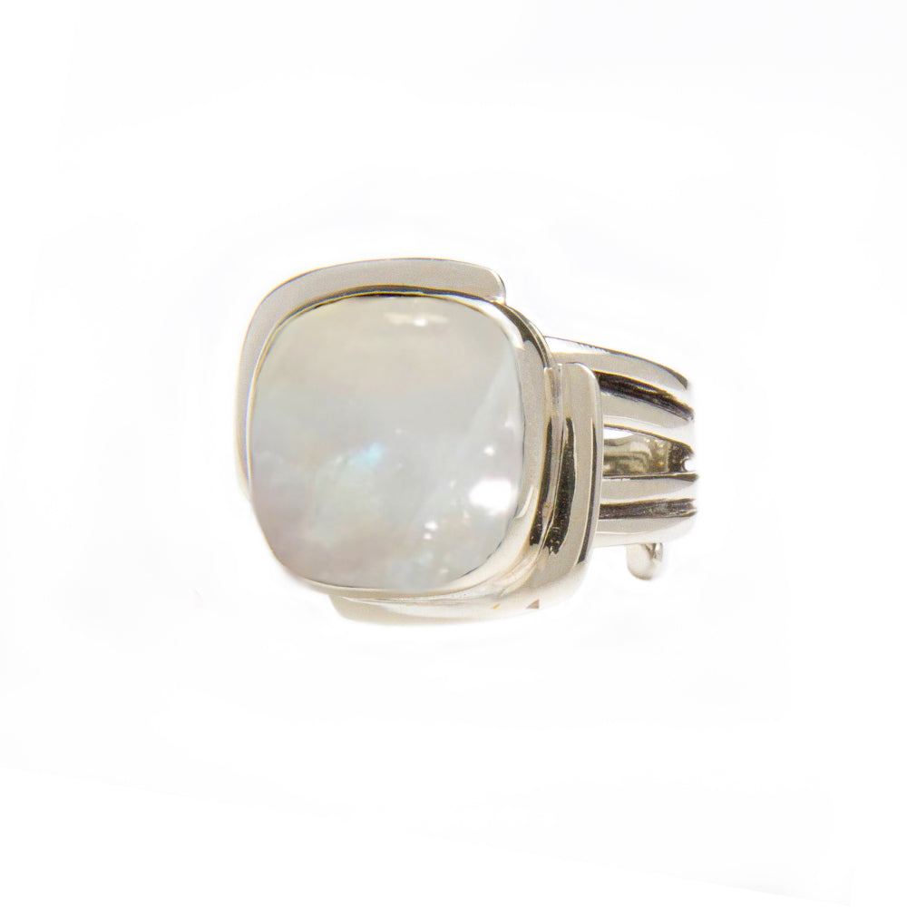 The Gallardo & Blaine Designs Art Deco Ring in Silver Gold & various gemstones features a large, square-cut white gemstone in the center. The band of the ring is composed of several parallel strips of silver, giving it a modern and sleek design reminiscent of an Art Deco ring. The gemstone has a subtle, iridescent glow.