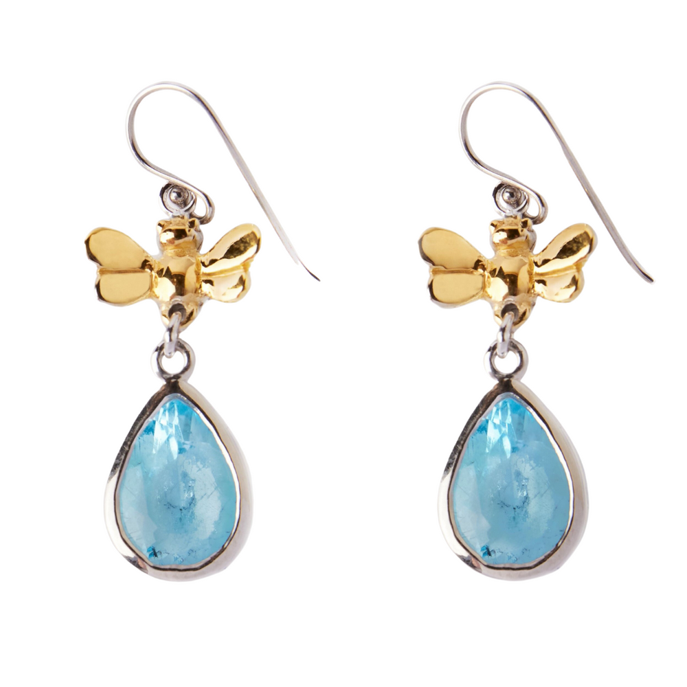 Introducing the Wildlife Bee Drops in various gemstones by Gallardo & Blaine Designs. A pair of elegant drop earrings featuring teardrop-shaped blue gemstones set in silver. The gemstones are suspended from small, gold-tone butterfly-shaped accents, which are attached to delicate silver hooks for wearing. Part of our wildlife collection, the design is dainty and sophisticated.