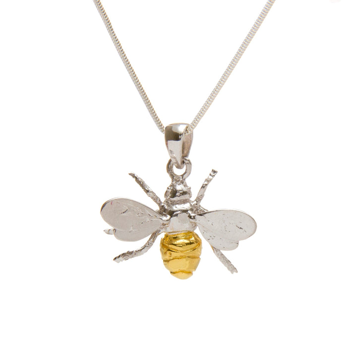 A close-up image of the Wildlife Pendant - Large Bee With Chain by Gallardo & Blaine Designs featuring a sterling silver bee pendant. The shiny, gold-plated bee body stands out beautifully against the delicate silver link chain. The plain white background highlights the exquisite craftsmanship of this charming design.