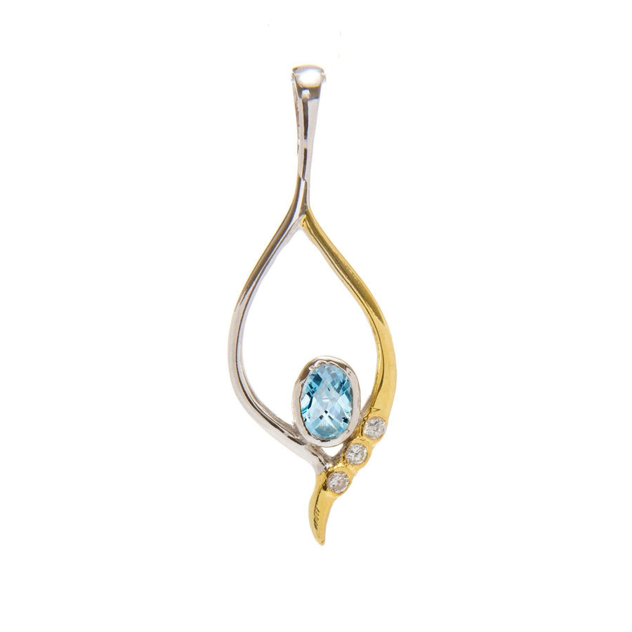 A Desert Star Pendant in various gemstones featuring an elegant, swirling gold vermeil and sterling silver design. It encloses a blue, oval-shaped gemstone and three small round diamonds adorned on the gold side. The pendant has a contemporary, delicate appearance by Gallardo & Blaine Designs.