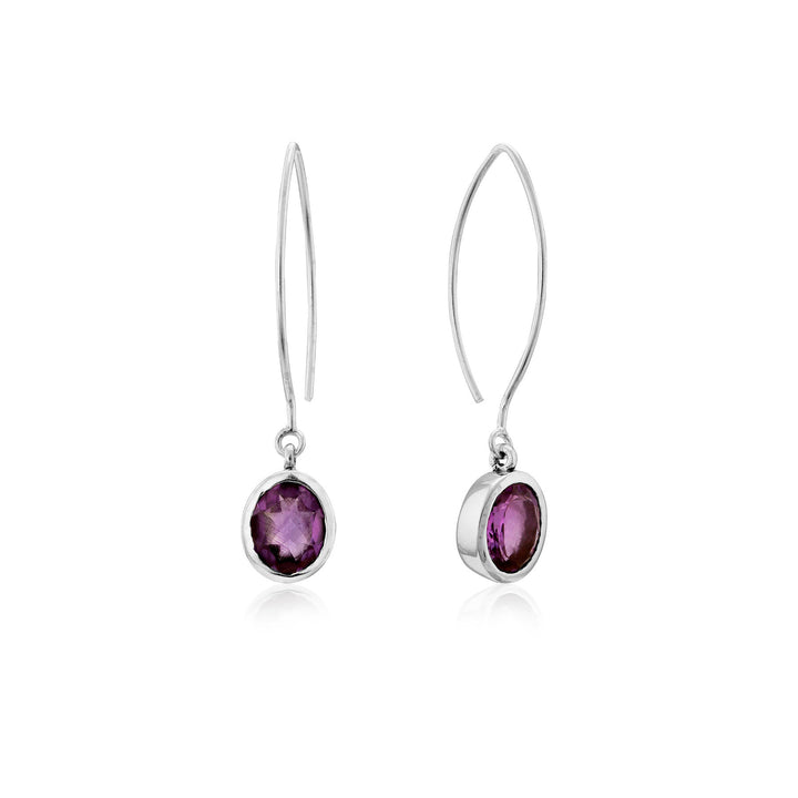 A pair of Dew Drop Earrings in various gemstones by Gallardo & Blaine Designs featuring round, faceted purple gemstones set in elegant sterling silver. The simple, curved hooks allow the gemstones to dangle freely, while the clean design emphasizes the vibrant color of the stones.