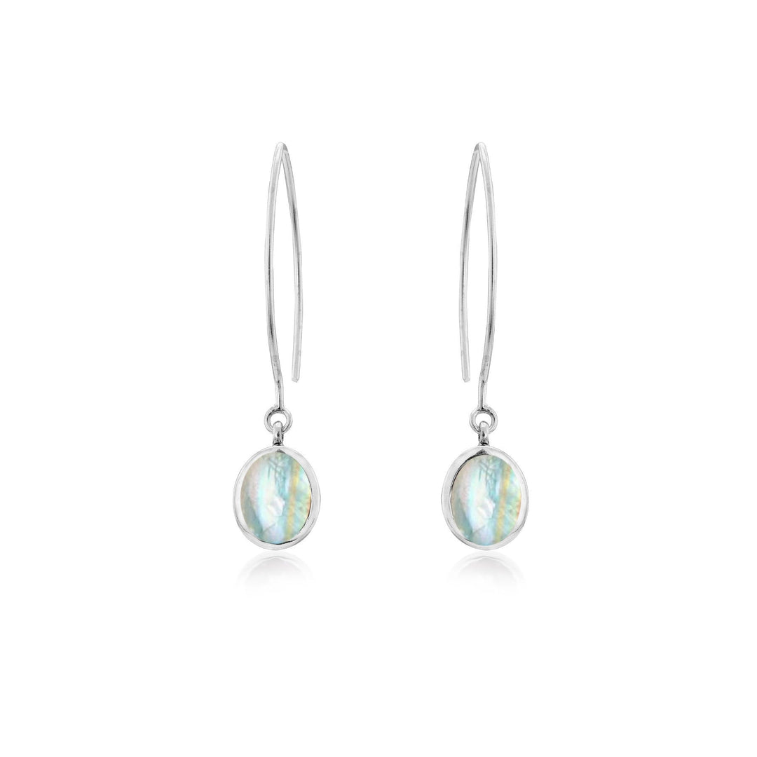 The Dew Drop Earrings in various gemstones by Gallardo & Blaine Designs feature oval-shaped, iridescent gemstones. The sterling silver earrings have a sleek and elegant design with a thin hook and a single hanging stone that reflects various shades of blue and green.