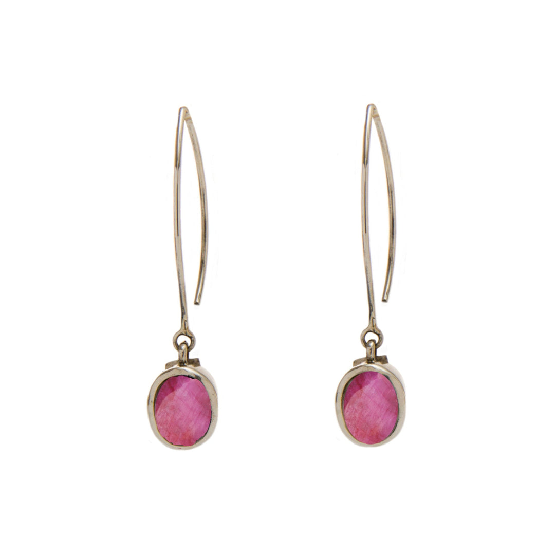 A pair of elegant Dew Drop Earrings in various gemstones with long, slender gold hooks from Gallardo & Blaine Designs. Each earring features an oval-shaped pink gemstone set in a gold bezel, dangling at the bottom. The gemstones have a faceted surface that catches the light.