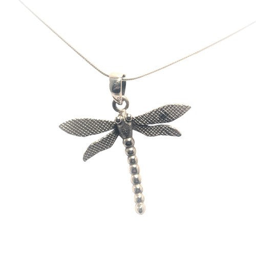 A silver pendant necklace featuring a detailed dragonfly design from our Wildlife Collection, the Wildlife Pendant - Large Dragonfly With Chain by Gallardo & Blaine Designs. The dragonfly pendant, with textured wings and a segmented body, is suspended elegantly from a thin silver snake chain. The overall look is delicate and elegant.