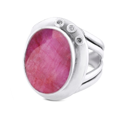 This statement **Eyetelia Ring in various gemstones** by **Gallardo & Blaine Designs** features a silver band with a large oval-shaped pink gemstone at its center. The smooth bezel setting is accented by small round diamonds on one side, and its adjustable design ensures a perfect fit.