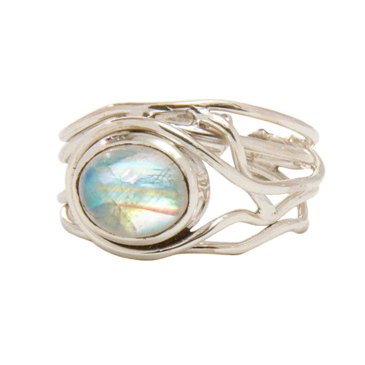 A Fossil Ring in silver & various gemstones, by Gallardo & Blaine Designs, features an intricate, vine-like design with a large, round, iridescent stone at its center. This adjustable ring displays a spectrum of colors, including shades of blue, green, and pink.