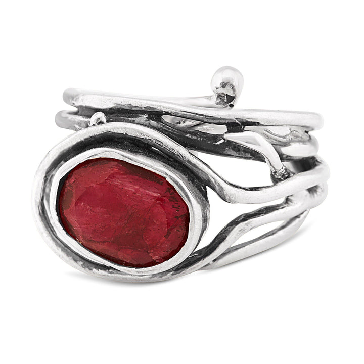 A Gallardo & Blaine Designs Fossil Ring in silver & various gemstones featuring a large, oval-shaped red gemstone set in an open, intertwined metal design. The adjustable ring has an organic, rustic aesthetic with uneven and textured silver strands wrapping around the gemstone.