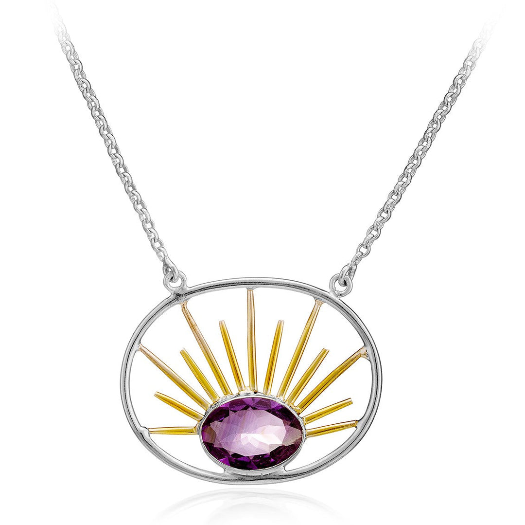 The Goddess Necklace Large in Various Gemstones by Gallardo & Blaine Designs features a stunning stone pendant with a purple gemstone at the center, surrounded by gold vermeil rays resembling a rising sun. The pendant hangs from a delicate silver chain.