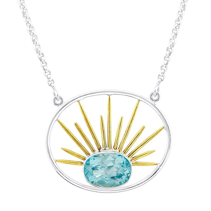 A silver necklace with a circular turquoise stone pendant at the bottom center, surrounded by golden sunbeam-like spikes in a sunburst design. The chain is delicate and made of gold vermeil, specifically the Goddess Necklace Large in Various Gemstones from Gallardo & Blaine Designs.