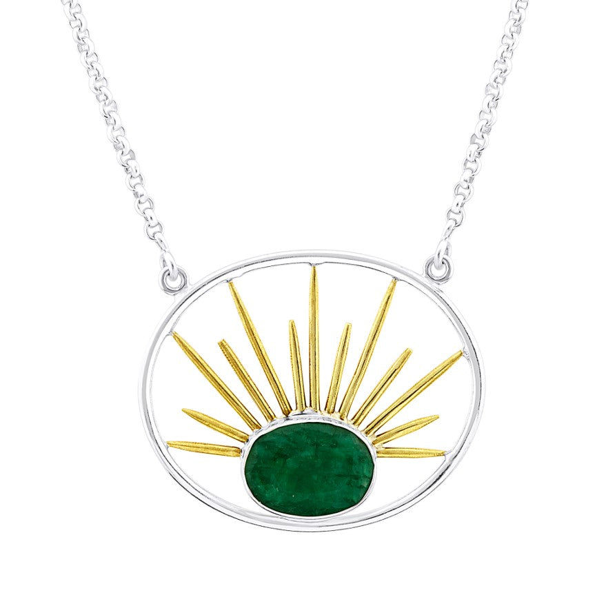 A silver Goddess Necklace Large in Various Gemstones with a gold vermeil chain features a circular pendant. Inside the circle, a green gemstone is set at the bottom center, with golden sunray-like lines radiating outward and upward from it, creating a sunburst effect. This exquisite piece is crafted by Gallardo & Blaine Designs.