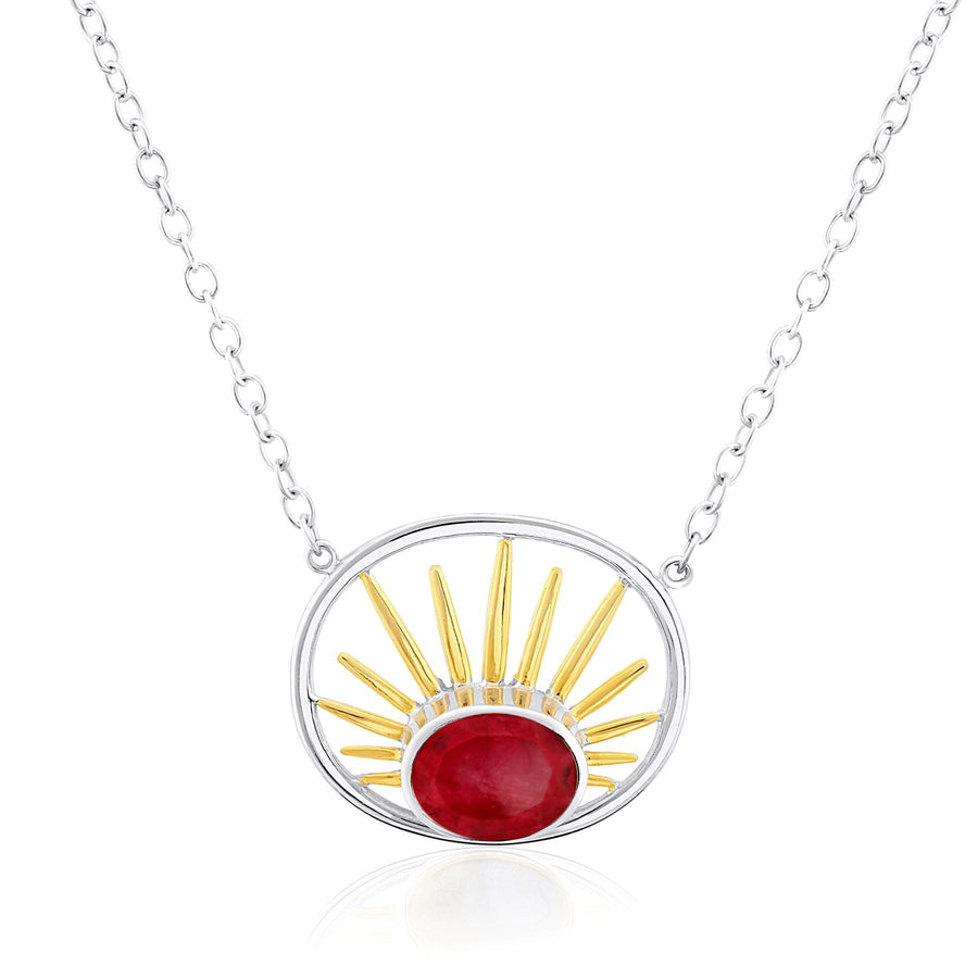 The Gallardo & Blaine Designs Goddess Necklace Small in various gemstones features a sterling silver chain and a round pendant. The pendant has a central red gemstone surrounded by a golden sunburst design, encased within a stunning silver circular frame.