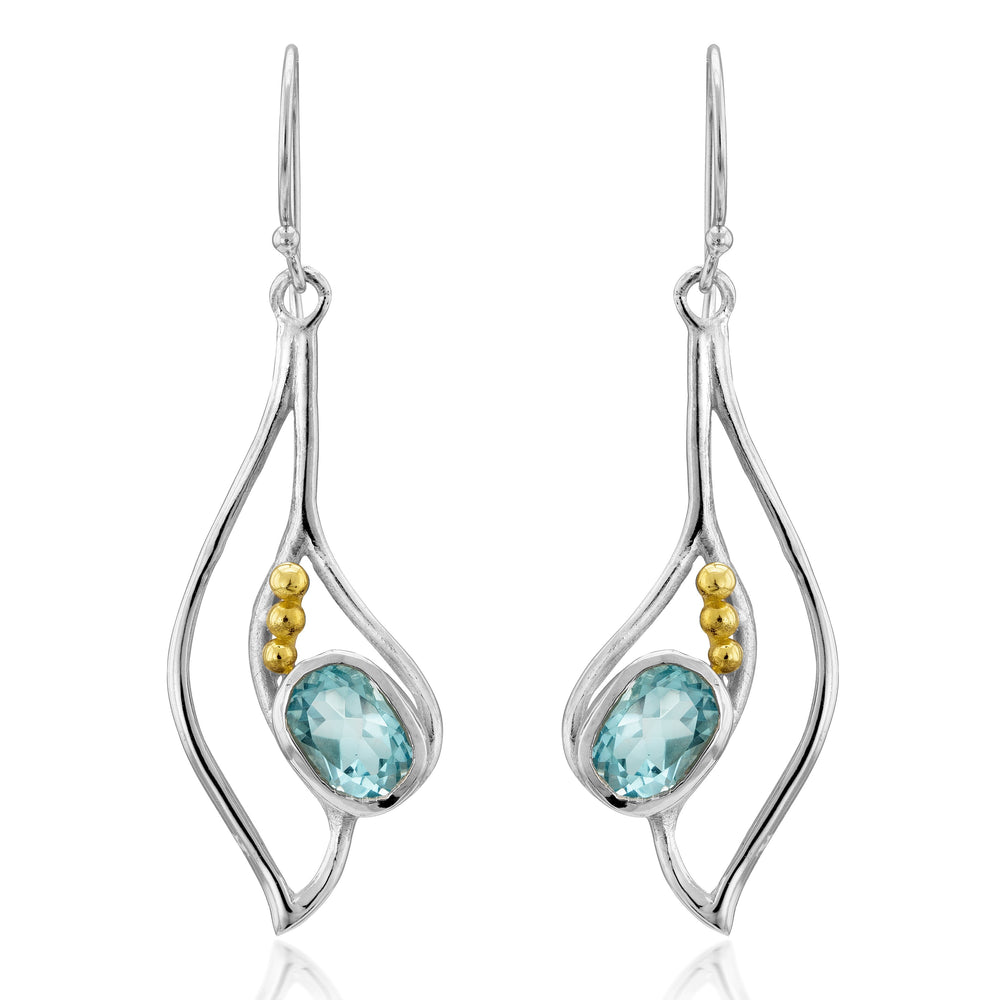 The Iris Earrings in various gemstones are elegant silver drop earrings featuring oval blue gemstones set in the center, each adorned with three small gold beads on the sides. These gemstone earrings hang from delicate hooks, showcasing a modern, fluid design with gentle curves and reflective surfaces. Gallardo & Blaine Designs offers these exquisite pieces that are sure to add a touch of sophistication to any ensemble.