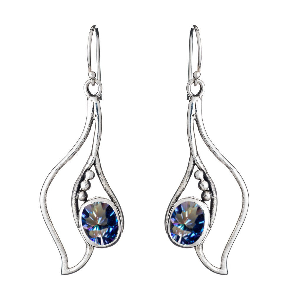 A pair of Iris Earrings in various gemstones with a wavy silver design, featuring a blue, sparkling gemstone at the center of each earring. The earrings hang by hooks and are accented with small metallic beads on one side. This exquisite piece is crafted by Gallardo & Blaine Designs.