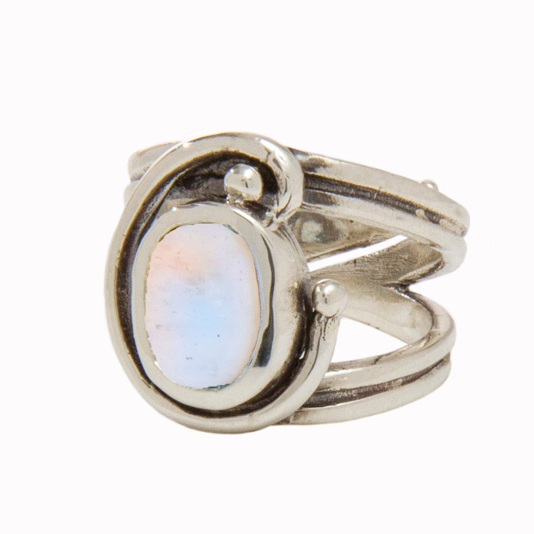 A silver Jasmine Ring in various gemstones by Gallardo & Blaine Designs featuring a large oval opal stone in the center. The band splits into three sections near the top, converging around the opal with a freeform design ending in small silver orbs. The stone has a milky, iridescent appearance with hints of blue and pink.