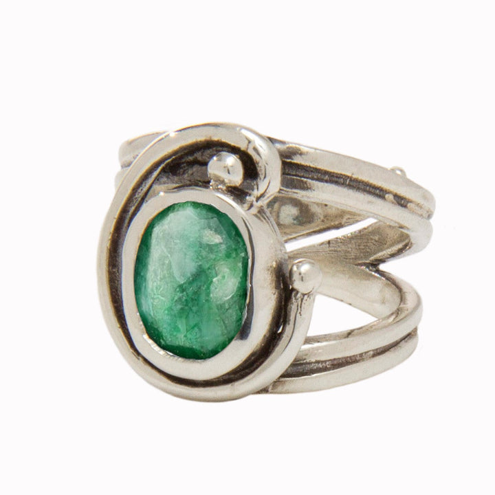 A silver Jasmine Ring in various gemstones featuring a green, oval-shaped stone set in a unique, swirling design. The band is split into three segments at the front, creating an open and artistic appearance around the gemstone, while its adjustable design ensures a perfect fit for any wearer by Gallardo & Blaine Designs.