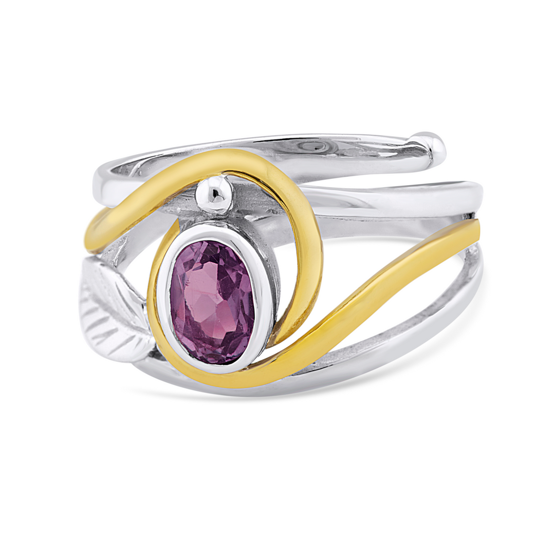 An elegant Leaf Ring in Silver Gold & various gemstones featuring a wrap-around design with a purple oval gemstone at its center. Silver & gold accents swirl around the gemstone, adding a touch of contrast and sophistication to the piece, reminiscent of a delicate piece by Gallardo & Blaine Designs.