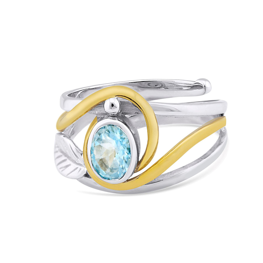 Introducing the Leaf Ring in Silver Gold & various gemstones by Gallardo & Blaine Designs: a silver and gold wave design ring featuring an oval-shaped blue gemstone in the center. This elegant gemstone ring boasts a modern, twisted band with a smooth yellow gold accent intertwining through the silver.