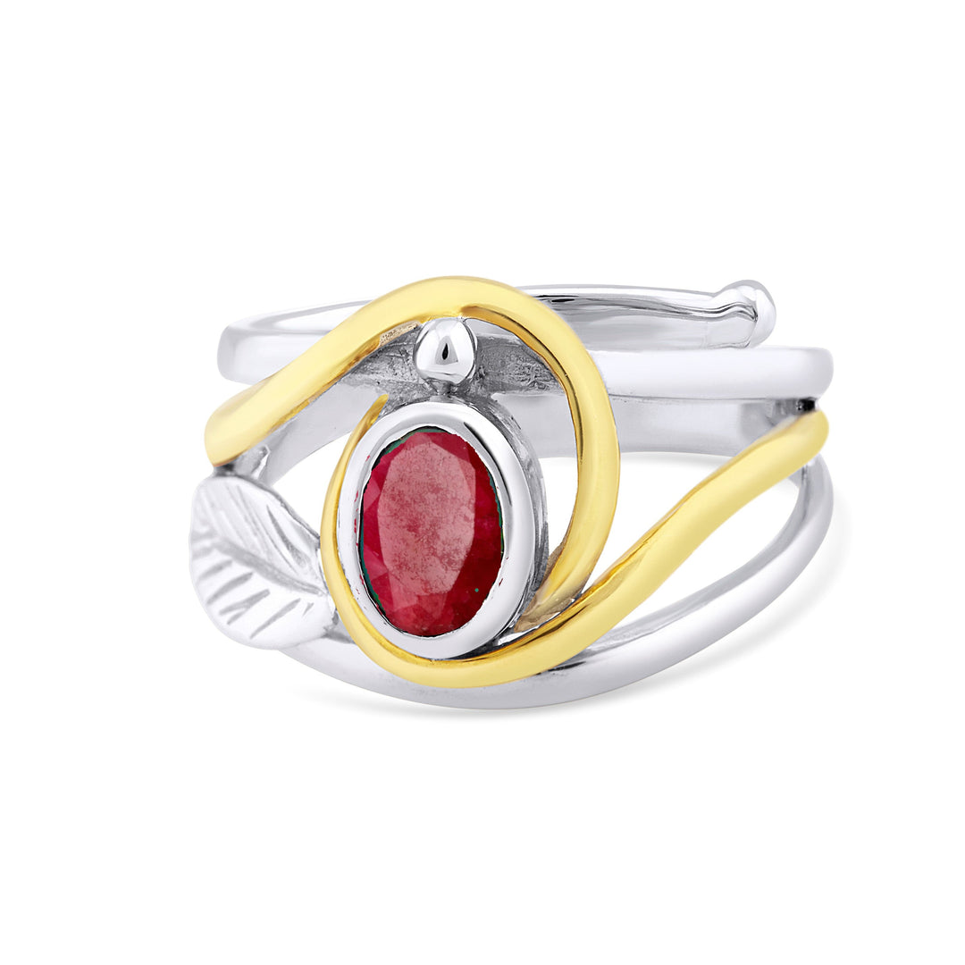 Introducing the "Leaf Ring in Silver Gold & various gemstones" by Gallardo & Blaine Designs: A multi-band leaf ring featuring a vivid red oval gemstone set in a silver bezel at the center. The intertwined ring bands display silver & gold tones, while a detailed silver leaf accents one side, creating an elegant and nature-inspired look.