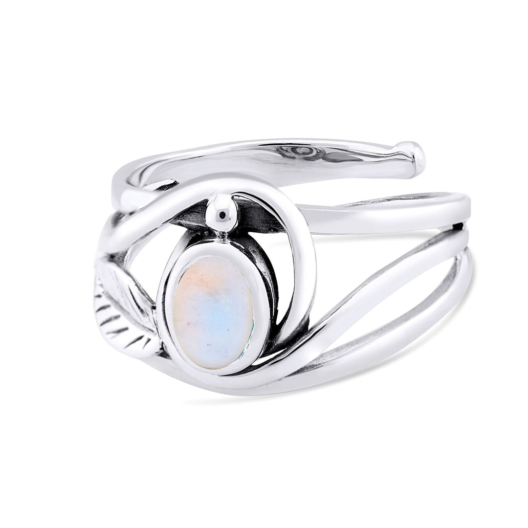 A stylish silver and gold ring featuring a smooth, oval-shaped, iridescent white gemstone set in a unique intertwined band design. The Leaf Ring in Silver Gold & various gemstones by Gallardo & Blaine Designs has flowing, wave-like elements, adding an elegant and modern touch to this elegant gemstone ring's overall appearance.