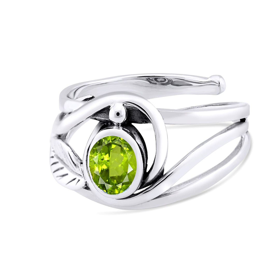 A silver & gold ring featuring an intricate, twisted band design. The centerpiece is a vibrant green gemstone, secured in a circular setting. Elegant and modern, this Leaf Ring in Silver Gold & various gemstones from Gallardo & Blaine Designs has a unique, flowing appearance.