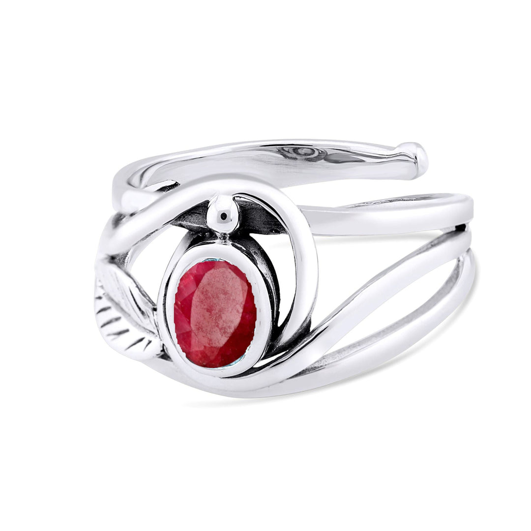 A Leaf Ring in Silver Gold & various gemstones by Gallardo & Blaine Designs with an oval-shaped red gemstone in a modern, sculptural setting featuring intertwining metal bands. This elegant gemstone ring has an asymmetrical design, with a sleek, polished finish and an artistic, contemporary feel.