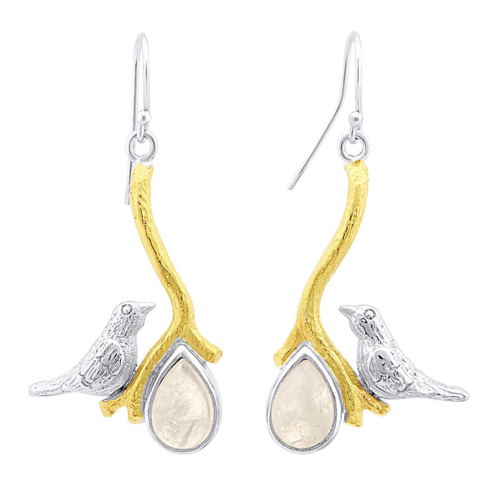 A pair of Lovebird Earrings in various gemstones by Gallardo & Blaine Designs featuring a design of two silver birds perched on gold-toned branches. Each branch holds a teardrop-shaped, translucent gemstone, creating an elegant and nature-inspired accessory. These statement earrings perfectly embody sophistication and charm.