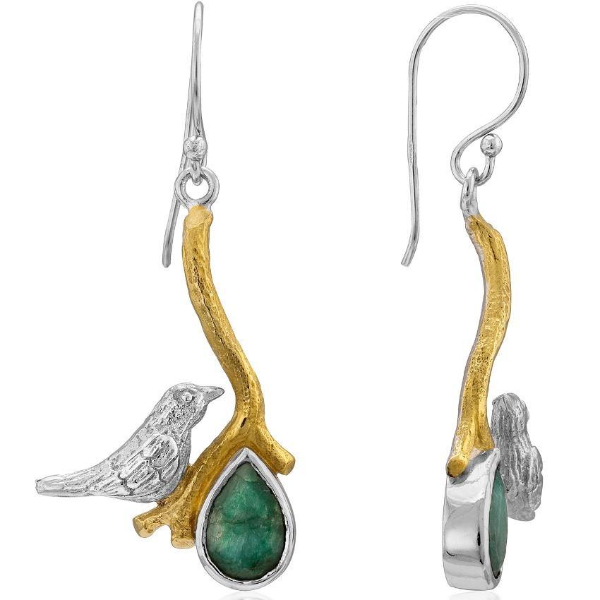 The Lovebird Earrings in various gemstones by Gallardo & Blaine Designs features a bird sitting on a golden branch. Each earring boasts a teardrop-shaped green gemstone hanging from the branch. The bird and branch design is silver with gold accents, creating a nature-inspired accessory that stands out.