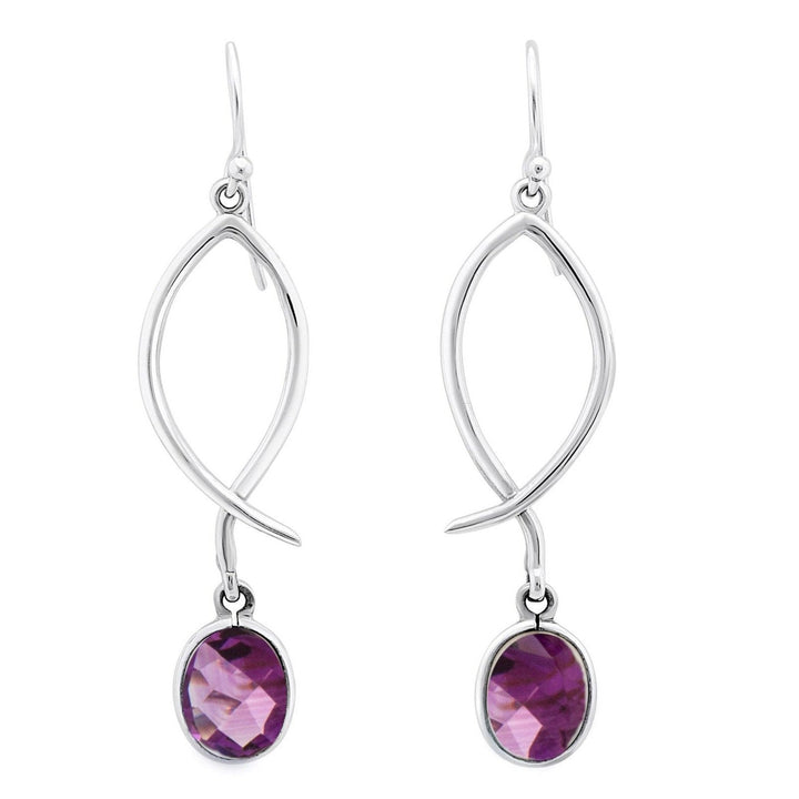 Presenting the Lupin Earrings in Various Gemstones by Gallardo & Blaine Designs: a pair of elegant drop silver earrings featuring an elongated twist design. Each earring showcases a dangling faceted purple gemstone in an oval shape, finished with a hook closure for pierced ears. Perfect for any occasion, these versatile earrings add sophistication to any ensemble.