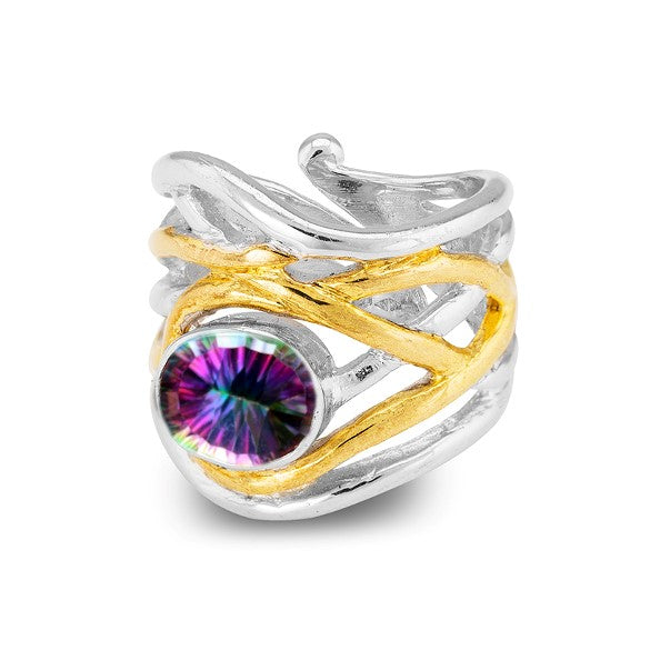 The Mayhem Ring in various gemstones by Gallardo & Blaine Designs is a silver and gold swirling band ring with a large, round, multicolored gemstone in the center. This chunky statement ring features an intricate, medieval-inspired design that intertwines beautifully around the vibrant stone.