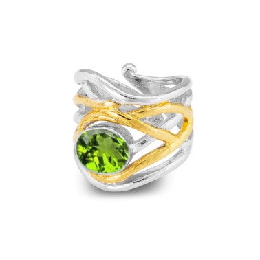 An elegant, adjustable ring featuring an intricate, dual-tone design with silver and gold bands intertwined. At the center, a vibrant green gemstone is set, adding a touch of brilliance to this medieval-inspired ornamental piece from Gallardo & Blaine Designs named Mayhem Ring in various gemstones.