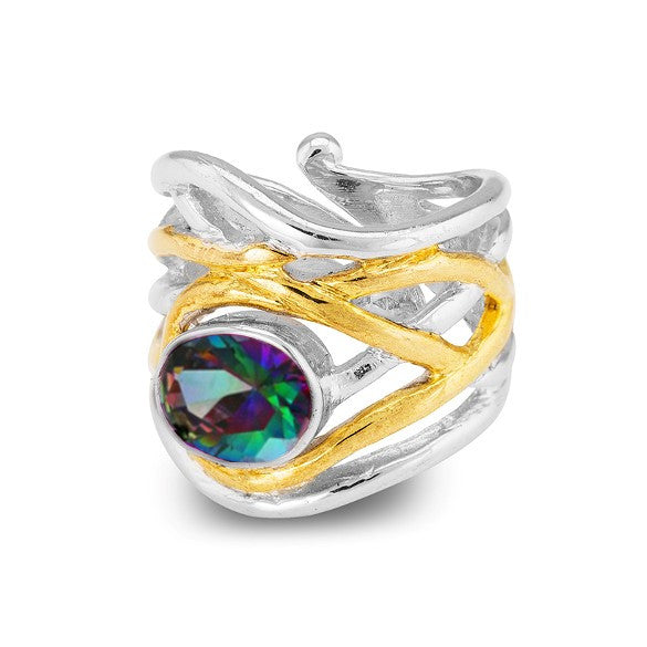 A silver ring with an intricate, wavy design, featuring a gold accent that wraps around the band. This chunky statement ring is adorned with a large, multicolored, faceted gemstone at the center, offering a touch of medieval-inspired jewelry flair. The Mayhem Ring in various gemstones by Gallardo & Blaine Designs.