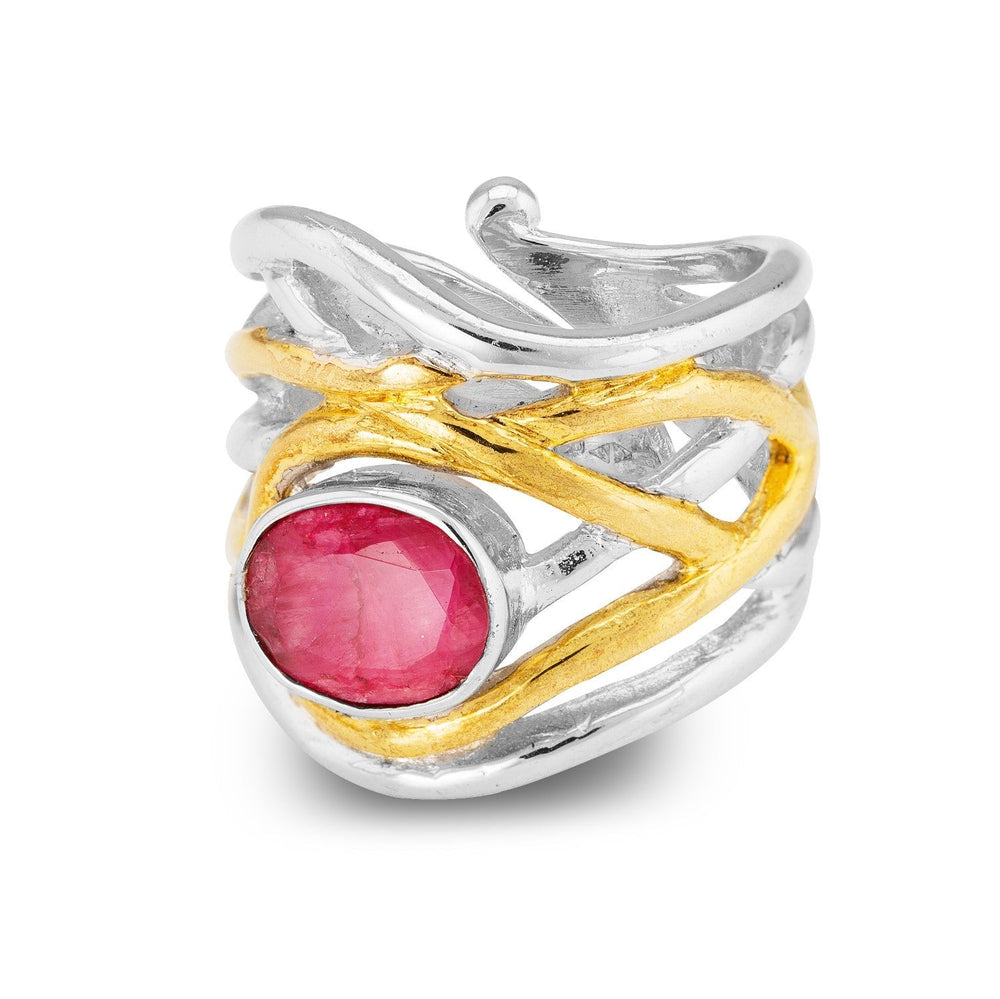 A silver and gold textured, chunky statement ring featuring an intricate design. The adjustable **Mayhem Ring in various gemstones** by **Gallardo & Blaine Designs** has a large, oval-shaped pink gemstone set in the center, with bands of silver and gold crossing over and around the stone, creating a swirling, medieval-inspired pattern.