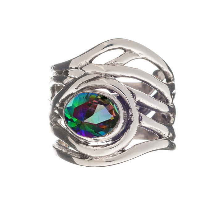 A close-up of the Mayhem Ring in various gemstones by Gallardo & Blaine Designs, featuring an intricate, wavy band design and a central, multifaceted gemstone that displays a gradient of green, purple, and blue colors. The detailed craftsmanship of the medieval-inspired jewelry is highlighted against a white background.