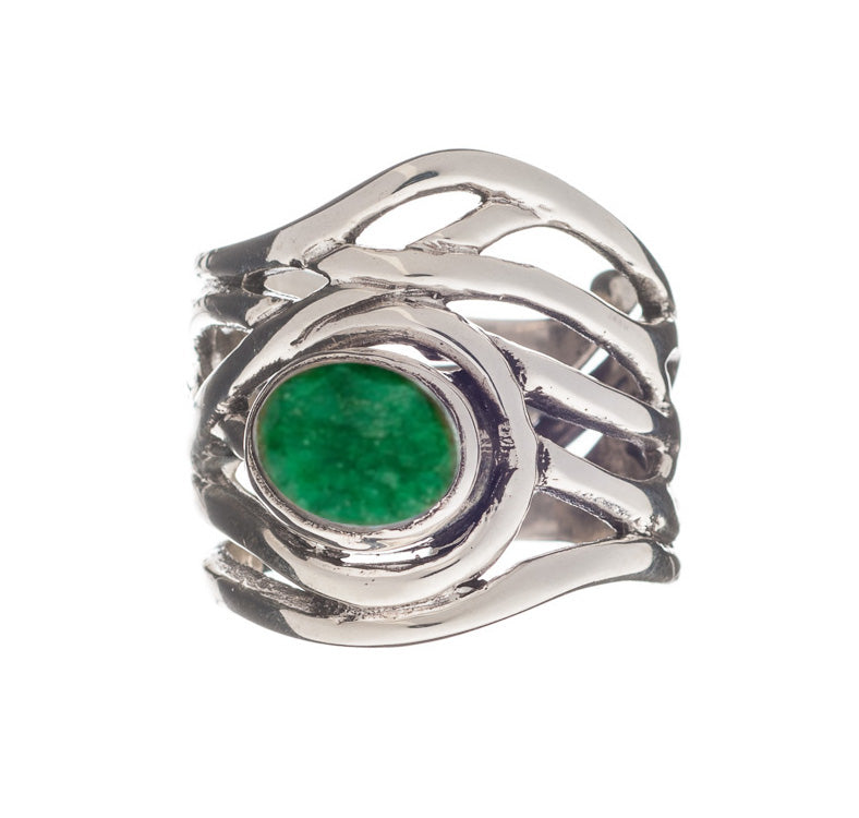 A chunky statement ring with an intricate, wavy band design, featuring an oval-shaped green stone set in the center. The Mayhem Ring in various gemstones by Gallardo & Blaine Designs has an adjustable silver band whose bright green gemstone contrasts brilliantly with the polished, reflective silver metal.