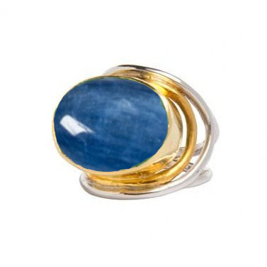 A sterling silver and gold adjustable ring featuring a large, oval-shaped blue gemstone. The design consists of intertwined metal bands accentuating the central stone. The glossy blue gemstone reflects light beautifully, making the Party Ring in various gemstones by Gallardo & Blaine Designs both bold and elegant.