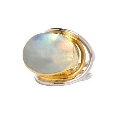 A statement Party Ring in various gemstones featuring an oval, iridescent white stone set in a creative, intertwined metal band composed of sterling silver & gold tones. The stone displays a subtle spectrum of colors, and the overall design is modern and elegant. This exquisite piece is from Gallardo & Blaine Designs.