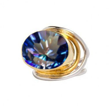 A sterling silver and gold Gallardo & Blaine Designs Party Ring in various gemstones with a large, faceted, oval-shaped gemstone displaying a sparkling array of blue, purple, and pink hues. The band features an intricate swirl design holding the gemstone securely in place. This statement Party Ring is perfect for any occasion.