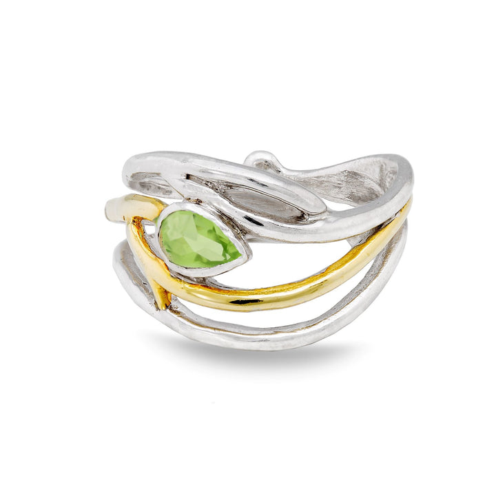 A stylish, twisted silver Gallardo & Blaine Designs Peacock Ring in various gemstones with a small leaf-like design, featuring a central, green, faceted gemstone. The ring is adorned with both polished silver and gold-toned accents, giving it a two-tone, elegant appearance. The adjustable band has an open, artistic design.