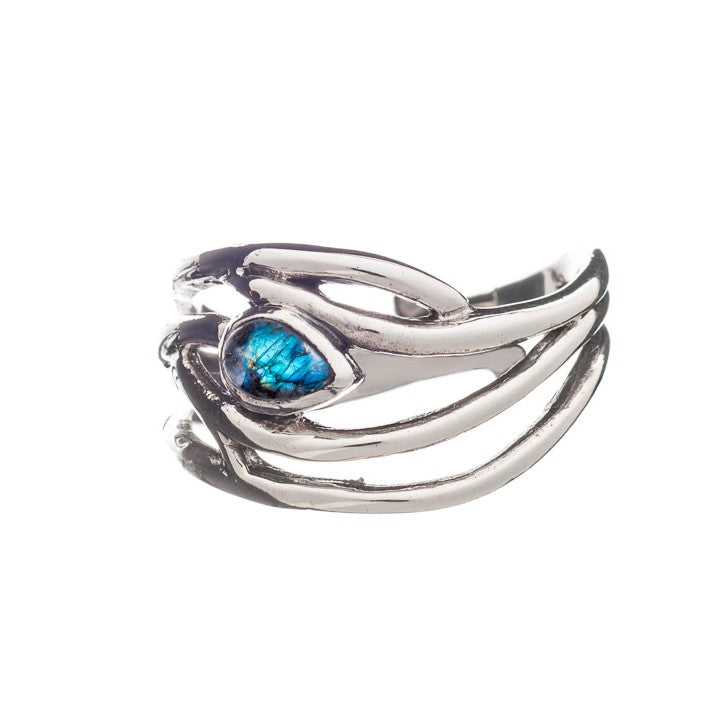 A Peacock Ring in various gemstones featuring a unique design mimicking branches or vines, with a central teardrop-shaped blue gemstone. The intricate detailing of this elegant dainty ring creates an artistic appearance, adjustable in silver & gold by Gallardo & Blaine Designs.