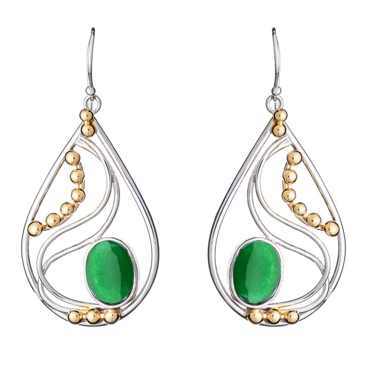 The Phoenix Earrings in various gemstones by Gallardo & Blaine Designs are a pair of elegant drop earrings featuring silver frames with decorative gold beads. Each earring showcases a large oval green stone set in the center, surrounded by intricate silver curves. These sophisticated silver and gold earrings hang gracefully from simple hooks.