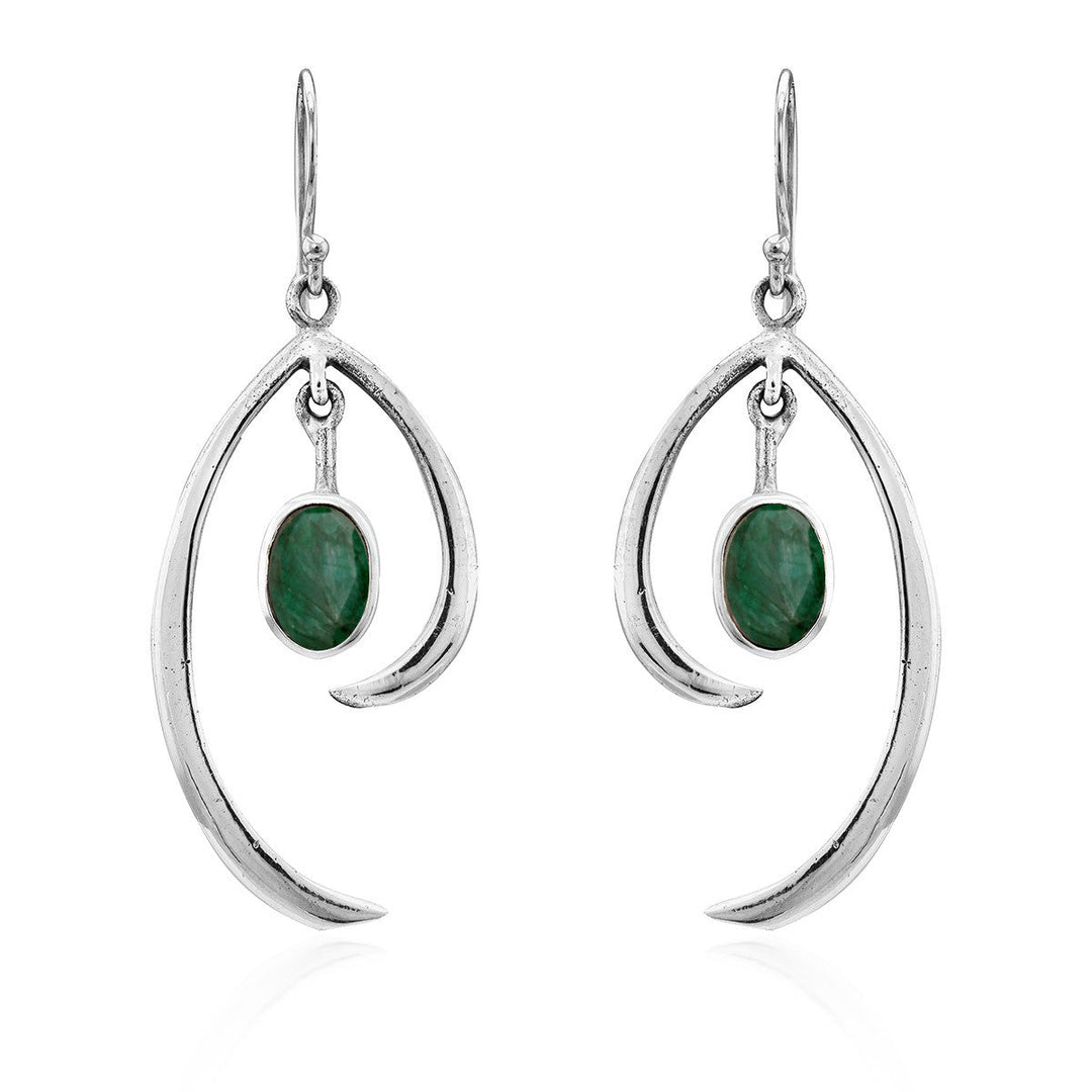 Discover the Primrose Earrings in various gemstones by Gallardo & Blaine Designs, a pair of sterling silver earrings that exude minimalist elegance. These silver drop earrings feature an abstract curved design with an oval green stone hanging in the center, all suspended from simple hooks.