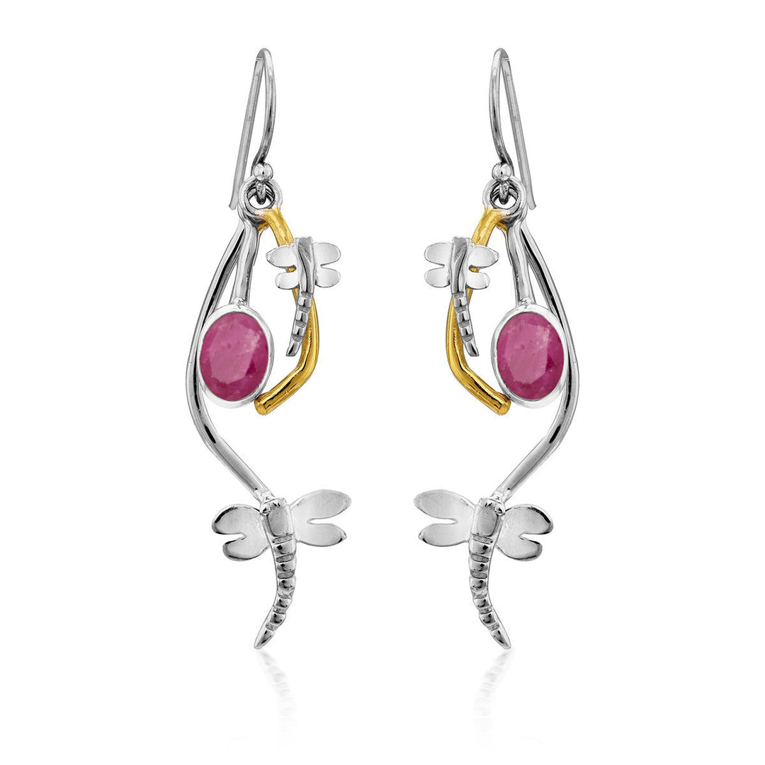 A pair of elegant, delicate Ripple Earrings in various gemstones featuring a dragonfly design. Each earring has a silver dragonfly with detailed wings, a curved silver accent, and a bright pink oval gemstone. A golden accent links the dragonfly to the hook, creating an intricate look for these Gallardo & Blaine Designs silver dangle earrings.