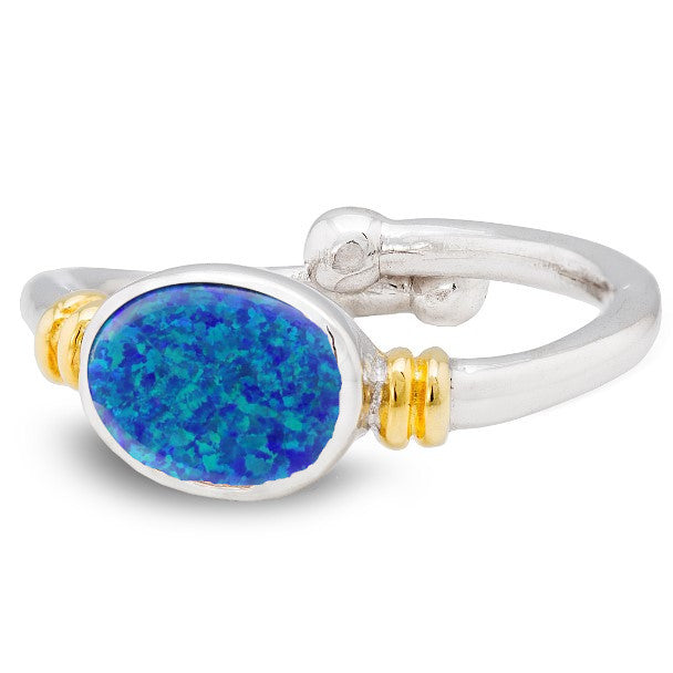 A silver, Art Nouveau Senna Ring in various gemstones by Gallardo & Blaine Designs featuring a blue oval opal stone set in the center. The band has gold accents on each side of the gemstone, and the split shank design offers adjustable comfort. The ring boasts a smooth, polished finish perfect for any occasion.