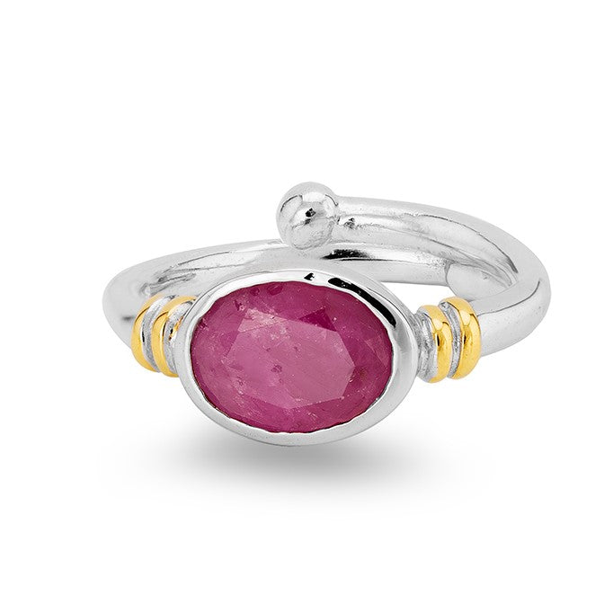 A silver Art Nouveau ring with a polished, oval-shaped pink gemstone in the center. The band features two small gold accents on each side of the stone, adding a touch of contrast to the design. This Senna Ring in various gemstones by Gallardo & Blaine Designs has a slightly rustic and handcrafted appearance.