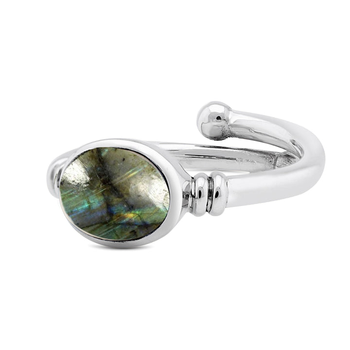 A Senna Ring in various gemstones by Gallardo & Blaine Designs with an oval labradorite stone that boasts an iridescent play of colors in shades of blue, green, and gray. The sleek, polished band features a minimalist design, making it the perfect blend of elegance and simplicity.