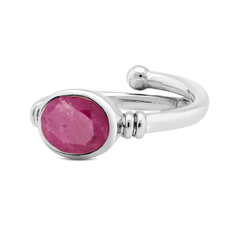 The Senna Ring in various gemstones by Gallardo & Blaine Designs features a striking oval-shaped pink stone in a bezel setting. The band is polished with a unique wrap-around design, and a small looped detail at the end gives it an Art Nouveau ring flair.